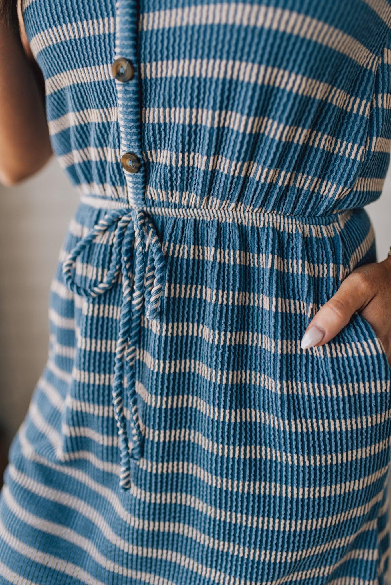 Blonde woman in a hat wearing a V-NECK, FAUX BUTTON UP, ELASTIC WAIST TIE, STRIPE DRESS WITH RIBBED TEXTURE knee length dress.