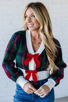 BLONDE WOMAN WEARING A VELVET BOW RIBBON EMBELLISHED CHRISTMAS CHECKER PLAID BUTTONED SWEATER CROP CARDIGAN