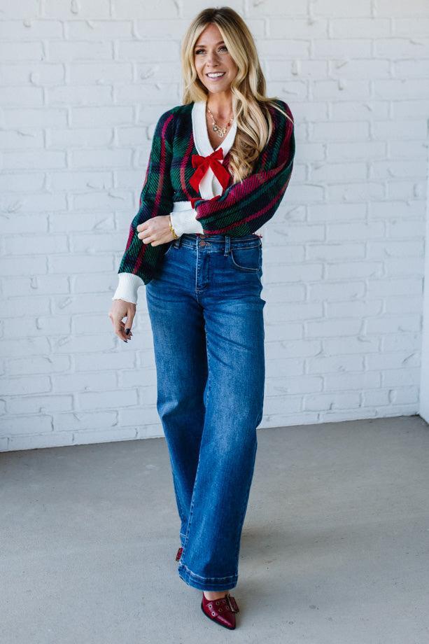 BLONDE WOMAN WEARING A VELVET BOW RIBBON EMBELLISHED CHRISTMAS CHECKER PLAID BUTTONED SWEATER CROP CARDIGAN