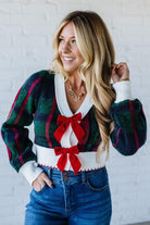 BLONDE WOMAN WEARING A VELVET BOW RIBBON EMBELLISHED CHRISTMAS CHECKER PLAID BUTTONED SWEATER CROP CARDIGAN
