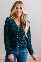 BLONDE WOMAN IN DARK JEANS WEARING A ROMANTIC VELVET BURNOUT TOP WITH FEATURES LIKE, BURNOUT VELVET MESH FABRICATION, SCALLOPED LACE EDGE ACCENTS, FUNCTIONAL BUTTONS AND LONG SLEEVES