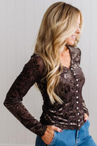 BLONDE WOMAN IN DARK JEANS WEARING A ROMANTIC VELVET BURNOUT TOP WITH FEATURES LIKE, BURNOUT VELVET MESH FABRICATION, SCALLOPED LACE EDGE ACCENTS, FUNCTIONAL BUTTONS AND LONG SLEEVES