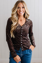 BLONDE WOMAN IN DARK JEANS WEARING A ROMANTIC VELVET BURNOUT TOP WITH FEATURES LIKE, BURNOUT VELVET MESH FABRICATION, SCALLOPED LACE EDGE ACCENTS, FUNCTIONAL BUTTONS AND LONG SLEEVES