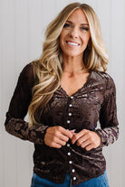 BLONDE WOMAN IN DARK JEANS WEARING A ROMANTIC VELVET BURNOUT TOP WITH FEATURES LIKE, BURNOUT VELVET MESH FABRICATION, SCALLOPED LACE EDGE ACCENTS, FUNCTIONAL BUTTONS AND LONG SLEEVES