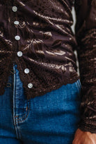 BLONDE WOMAN IN DARK JEANS WEARING A ROMANTIC VELVET BURNOUT TOP WITH FEATURES LIKE, BURNOUT VELVET MESH FABRICATION, SCALLOPED LACE EDGE ACCENTS, FUNCTIONAL BUTTONS AND LONG SLEEVES
