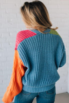 blonde girl modeling a bright colorblock cardigan with chunky wood buttons