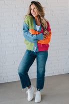 blonde girl modeling a bright colorblock cardigan with chunky wood buttons