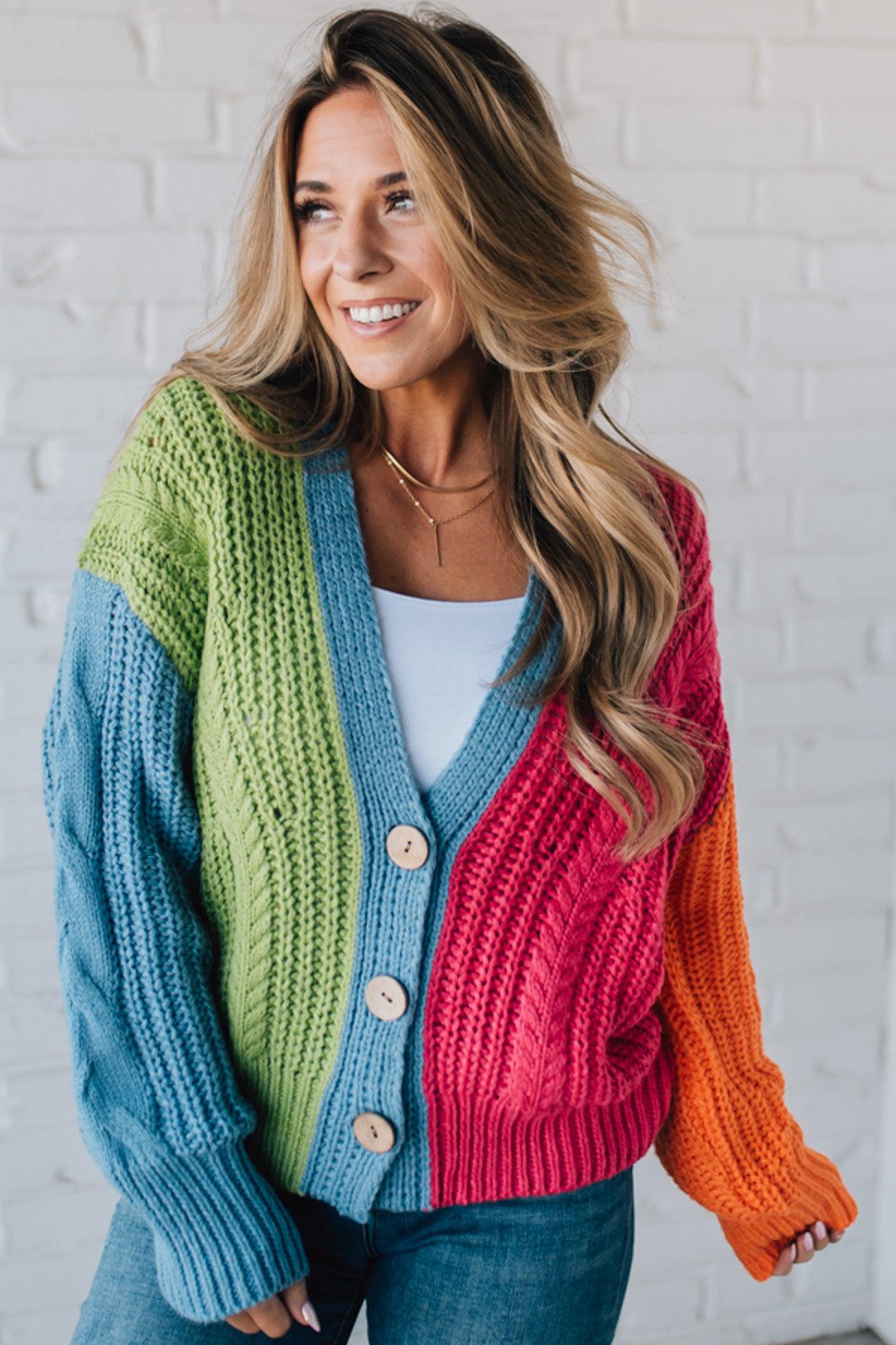 blonde girl modeling a bright colorblock cardigan with chunky wood buttons