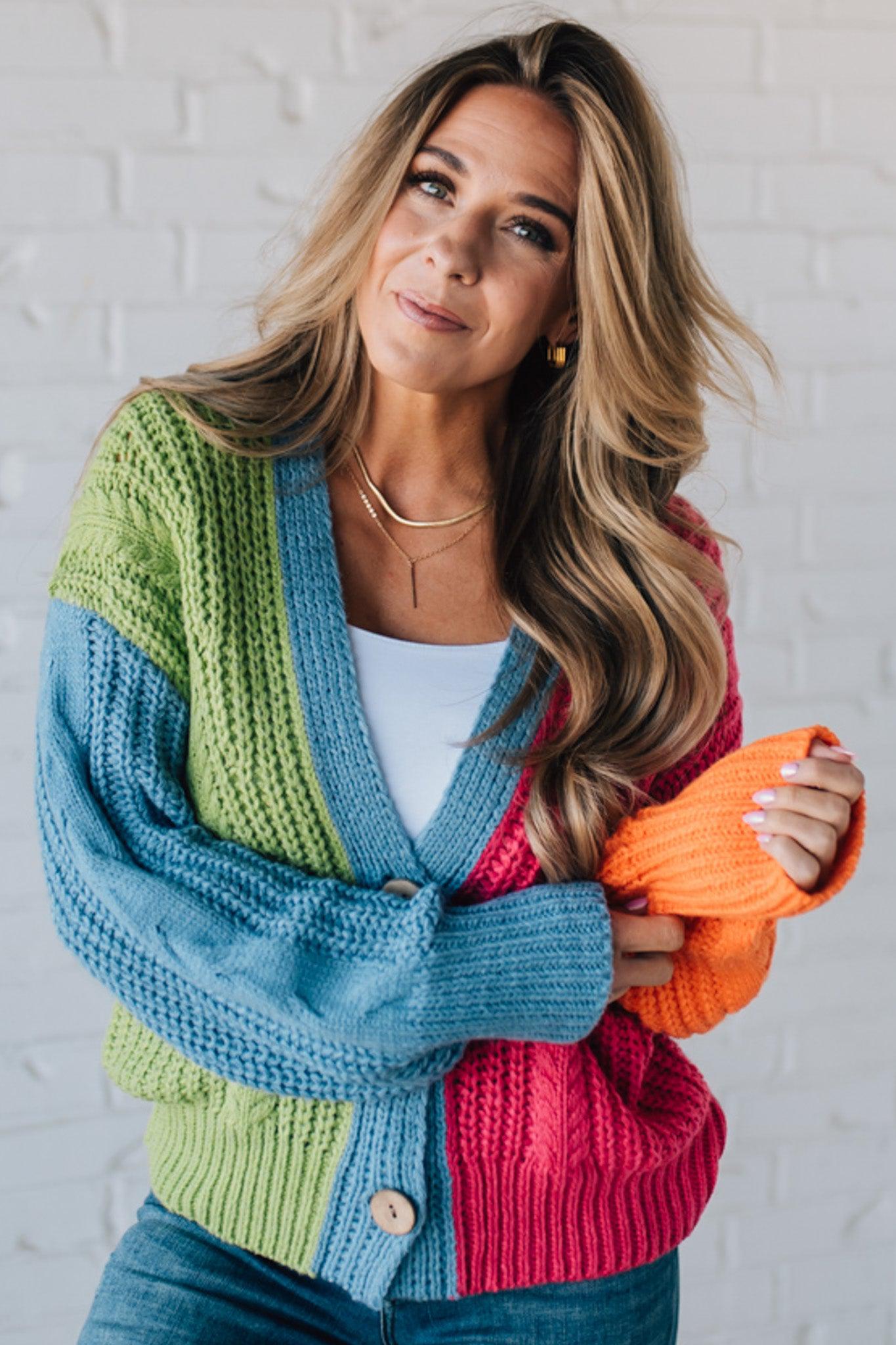 blonde girl modeling a bright colorblock cardigan with chunky wood buttons