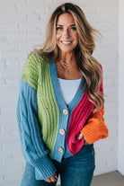 blonde girl modeling a bright colorblock cardigan with chunky wood buttons