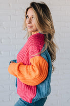 blonde girl modeling a bright colorblock cardigan with chunky wood buttons