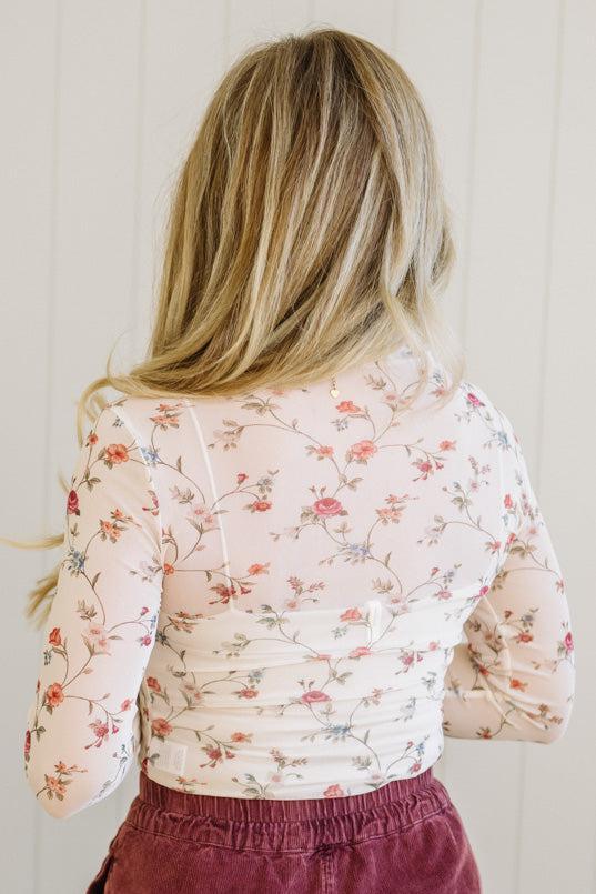 Woman wearing a floral blouse with a plain background