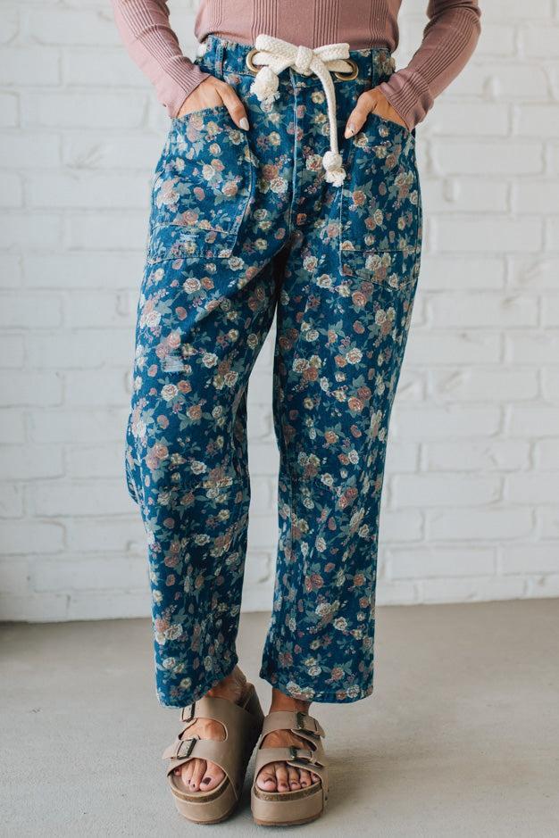 Person wearing blue floral pants with a white background