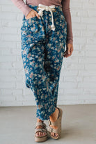 Person wearing blue floral pants with a white background