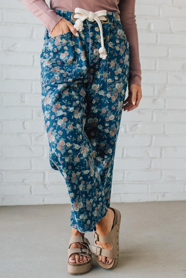Person wearing blue floral pants with a white background