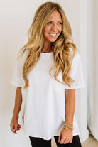 Woman wearing a white t-shirt against a plain background