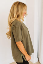 Woman wearing an olive green shirt against a white background