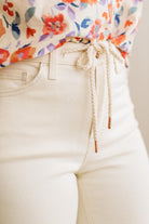 Close-up of a person wearing a colorful floral shirt and beige pants with a blurred background