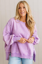 Woman wearing a purple sweater with a plain background