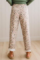 Woman Standing on Light Wood Floor with a Paneled Wall behind and wearing a green shirt, light tan slip on loafers and Delicate Wildflower Harmony Classic Fit Trouser Pants.