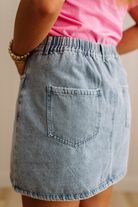 Person wearing a denim skirt with a blurred background