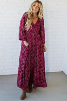 Blonde Woman Wearing a Smocked Floral Maxi Dress with Button Front and v-neckline in a deep wine red color.