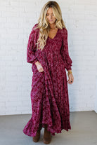 Blonde Woman Wearing a Smocked Floral Maxi Dress with Button Front and v-neckline in a deep wine red color.