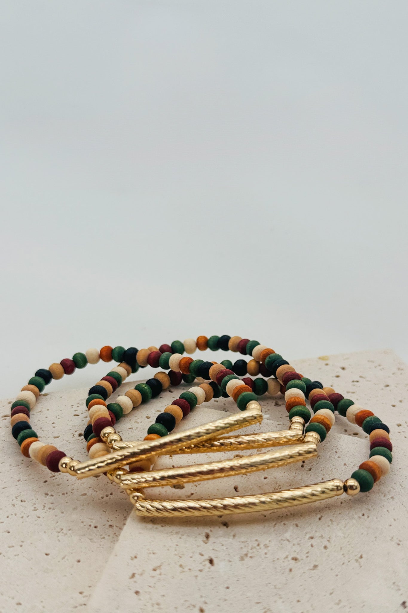 Multicolored beaded bracelet with gold accents on a light background