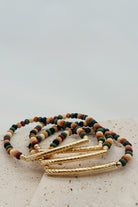 Multicolored beaded bracelet with gold accents on a light background