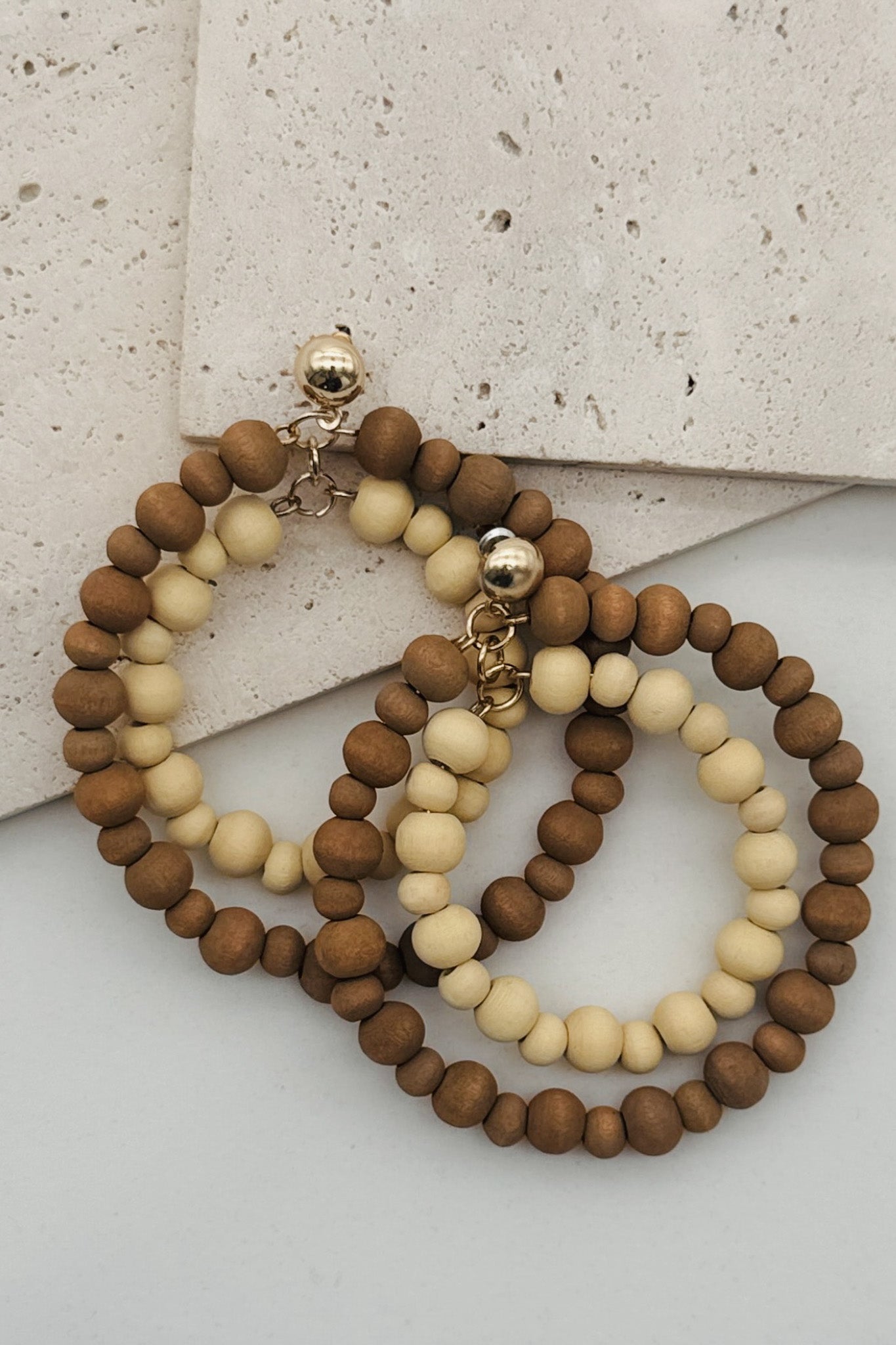 A pair of wood beaded hoop earrings.