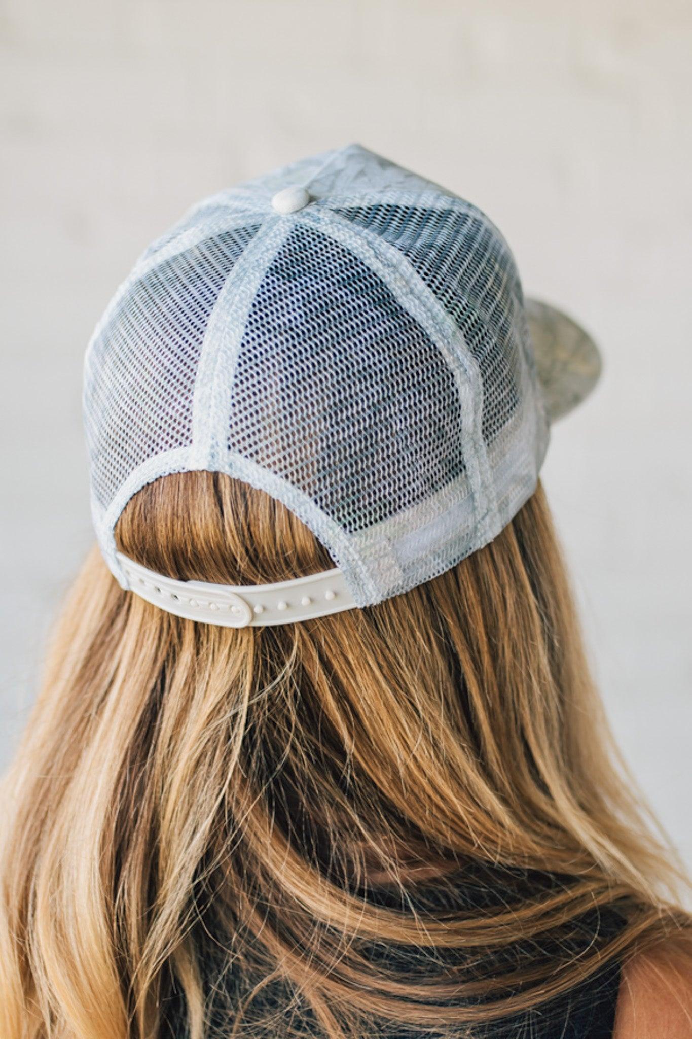 Blonde Woman Wearing a White Woods Print Mesh Back Trucker Cap.