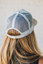 Blonde Woman Wearing a White Woods Print Mesh Back Trucker Cap.