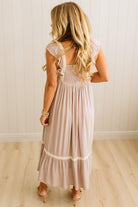 Woman wearing a long, light-colored dress with a white background