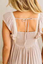 Woman wearing a light pink dress with a backless design.