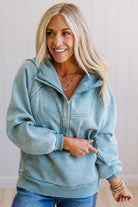 Woman wearing a light blue hoodie with a neutral background